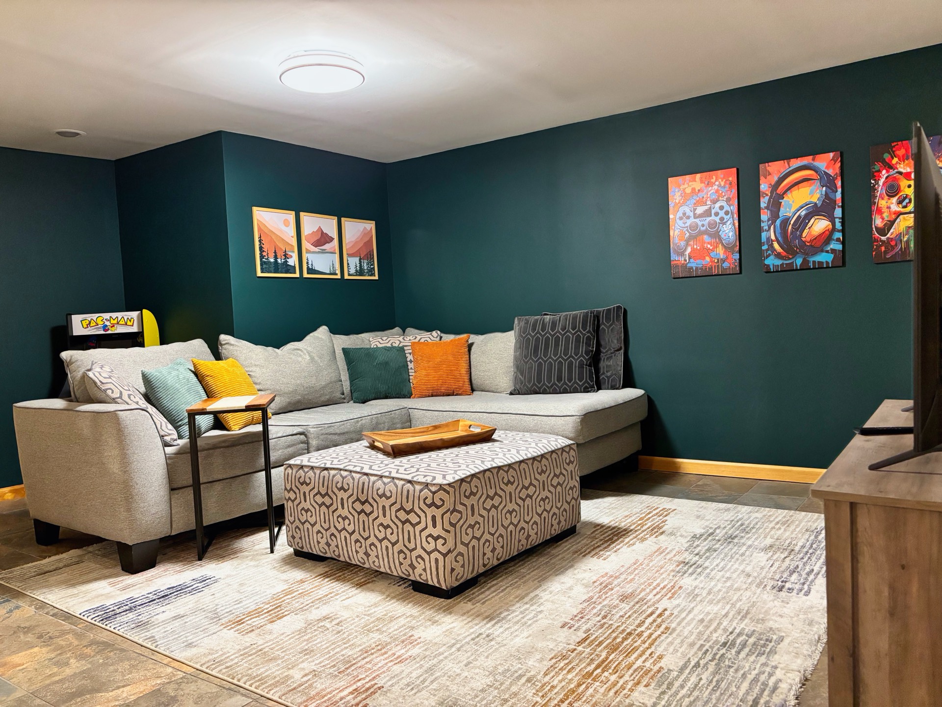 Basement lounge with sectional sofa and colorful art