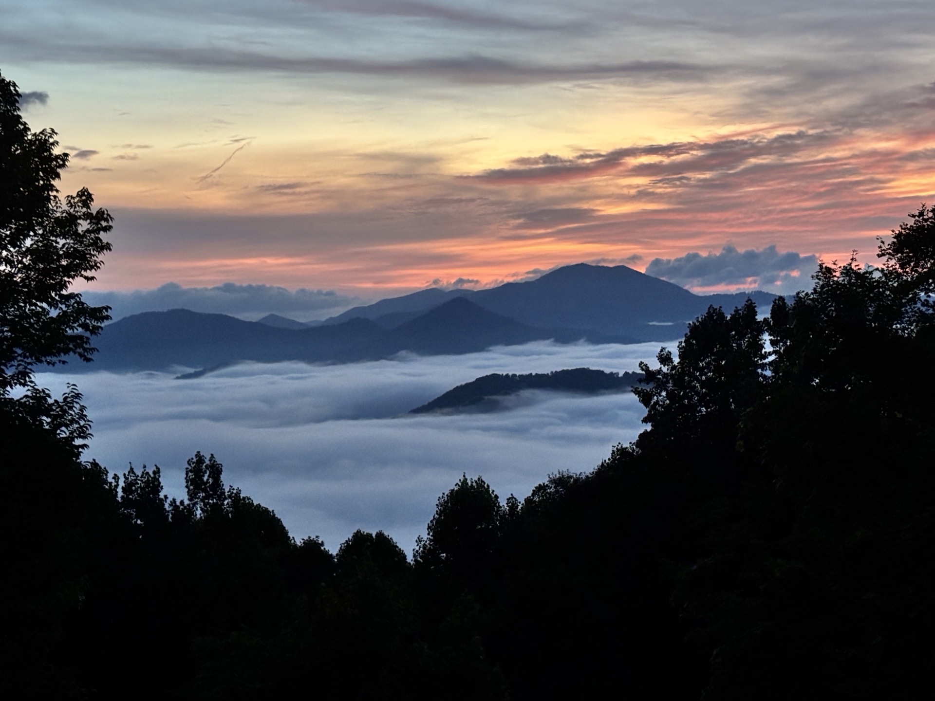 Layered mountain ridges above a sea of clouds at dawn