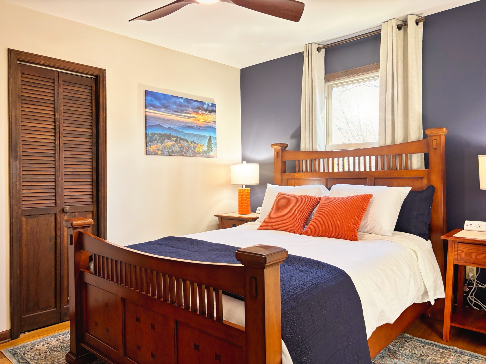 Guest bedroom with navy accent wall and queen bed