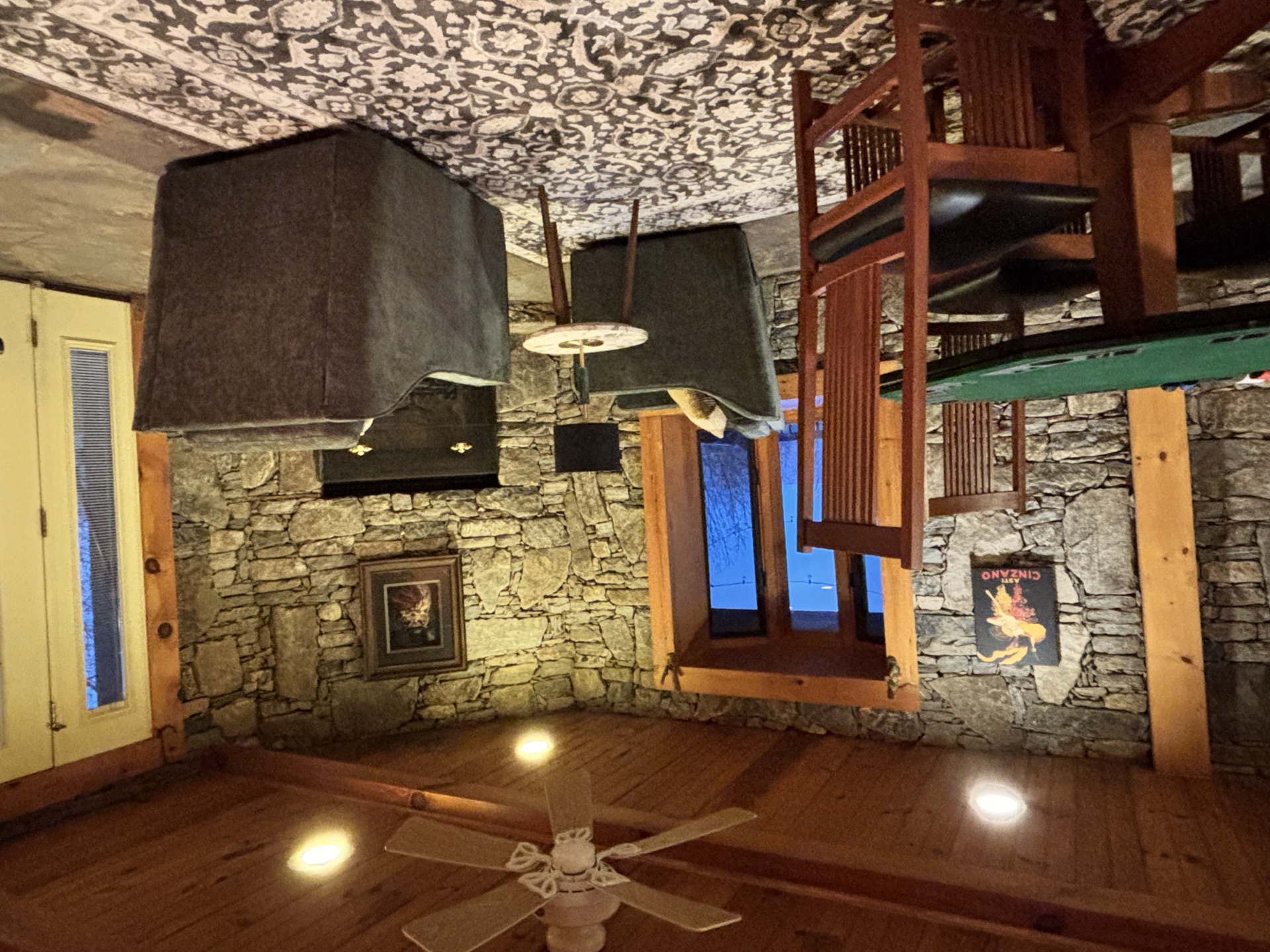 Basement pub with stone fireplace and armchairs
